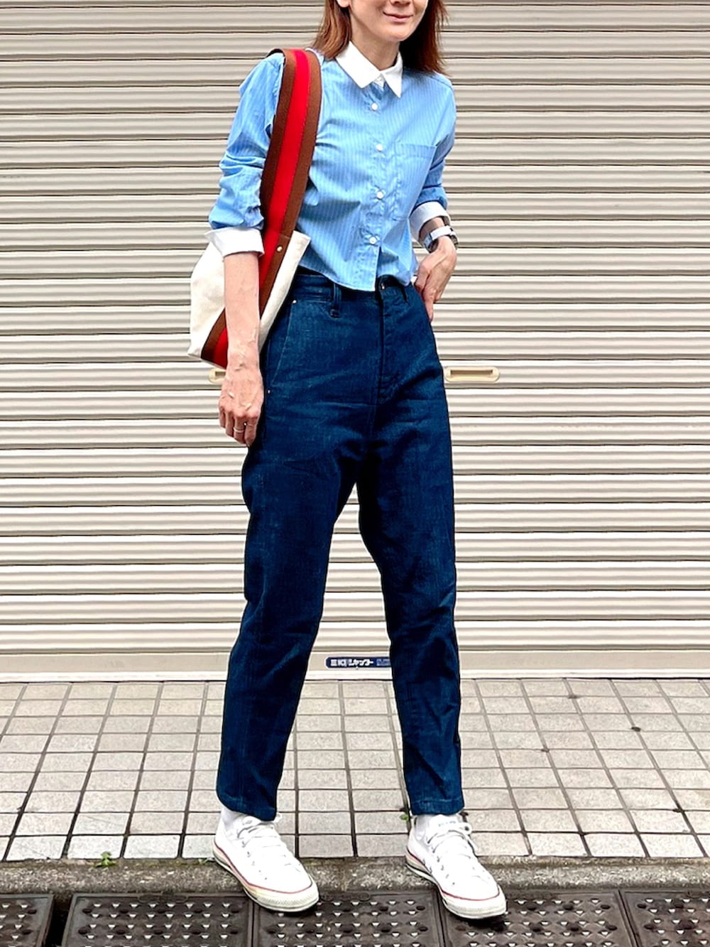 ブルー系のシャツ/ブラウス、ブラウン系のショルダーバッグ、ブルー系のデニムパンツを着用したレディースの夏コーディネートの2枚目の写真