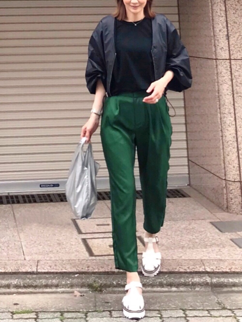 ブラック系のブルゾン、シルバー系のエコバッグ/サブバッグ、グリーン系のその他パンツを着用したレディースの春コーディネートの2枚目の写真