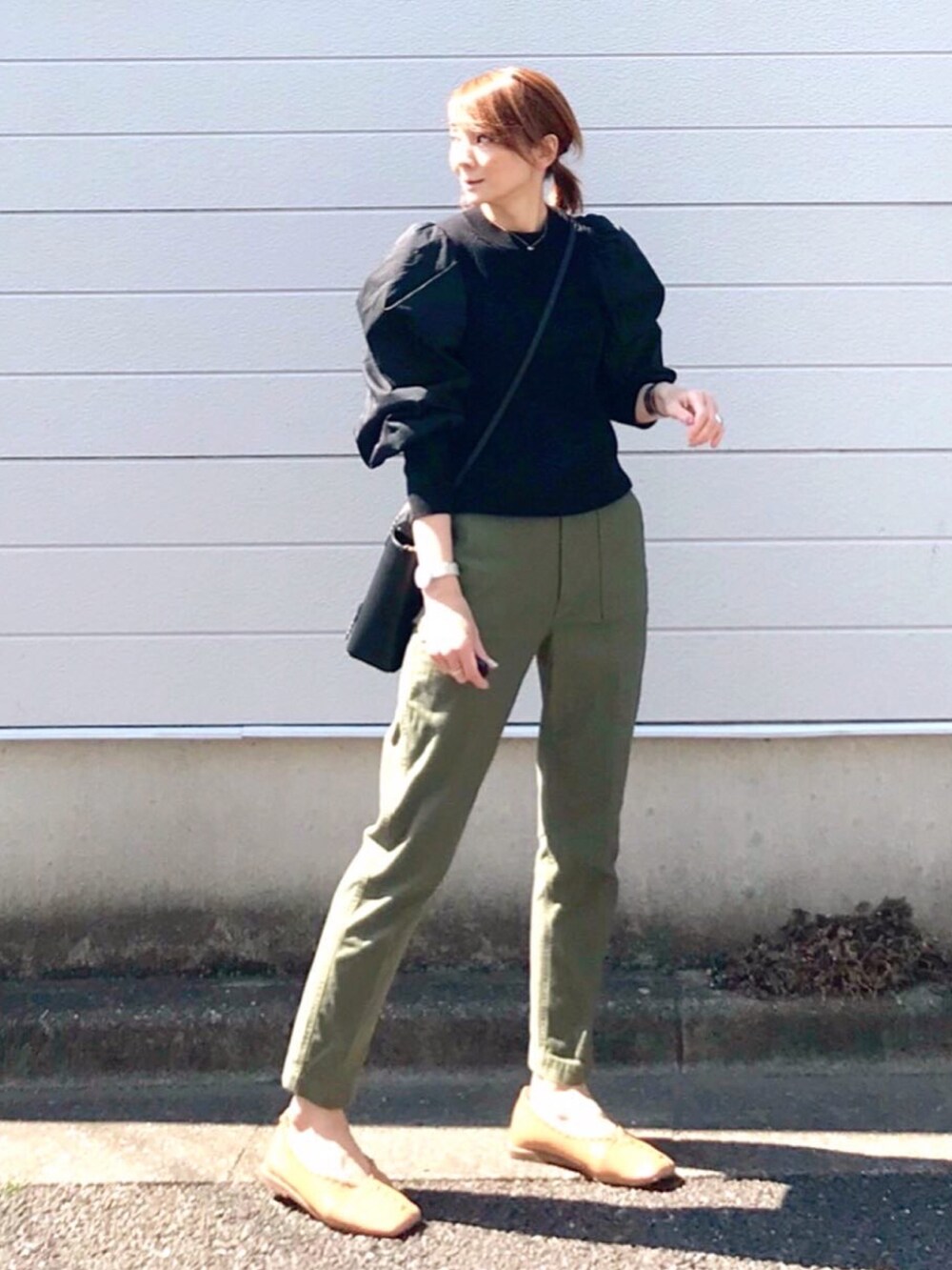 ブラック系のニット/セーター、ブラック系のトートバッグ、ベージュ系のパンプスを着用したレディースの春コーディネートの2枚目の写真