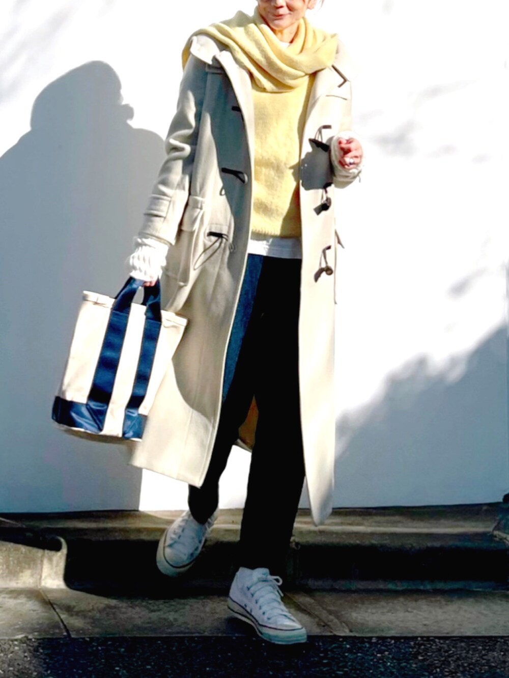 ホワイト系のスニーカー、ホワイト系のトートバッグ、ブルー系のデニムパンツを着用したレディースの冬コーディネートの2枚目の写真