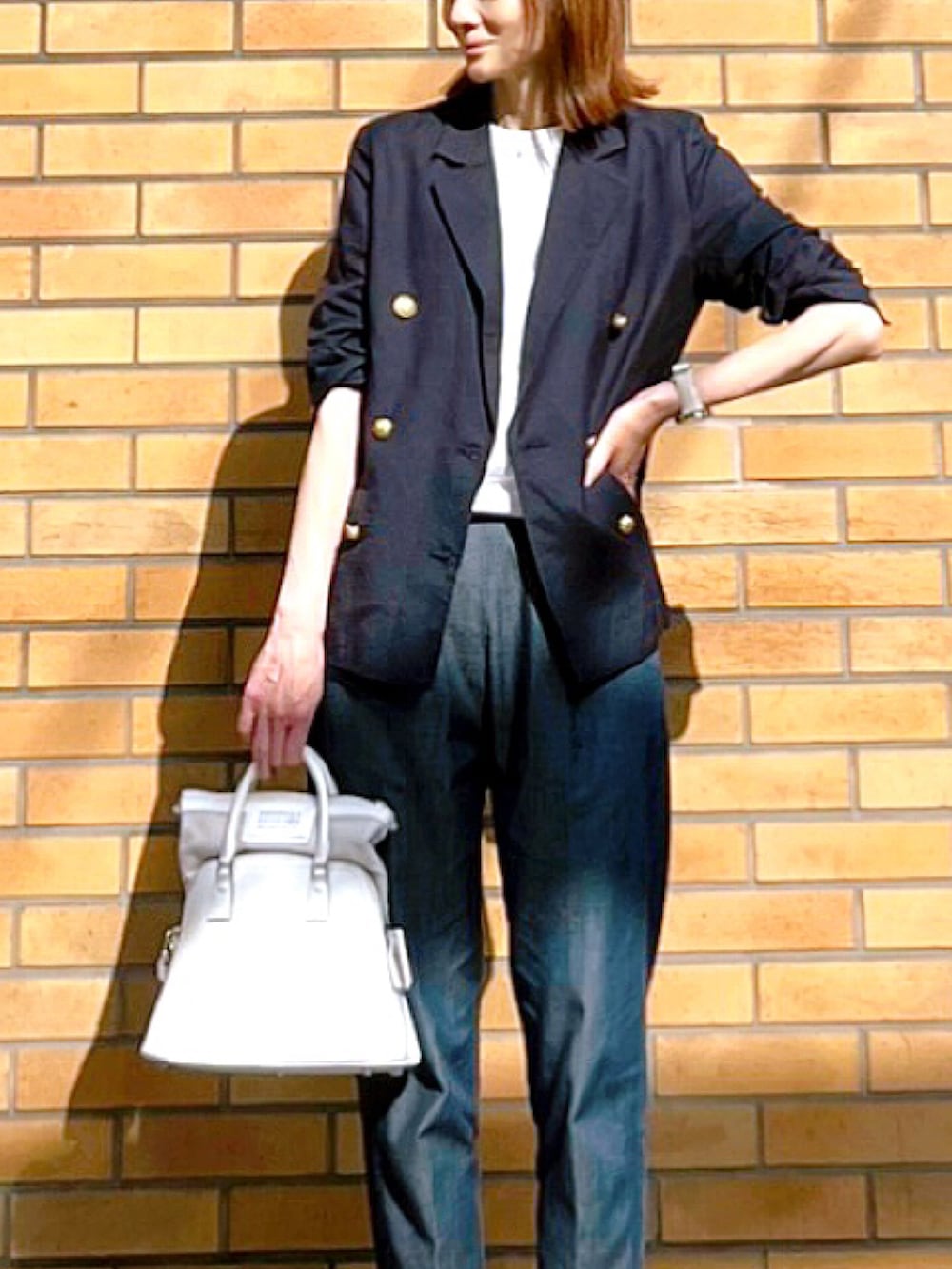 ホワイト系のハンドバッグ、ブルー系のテーラードジャケット、ブルー系のその他パンツを着用したレディースの春コーディネートの2枚目の写真