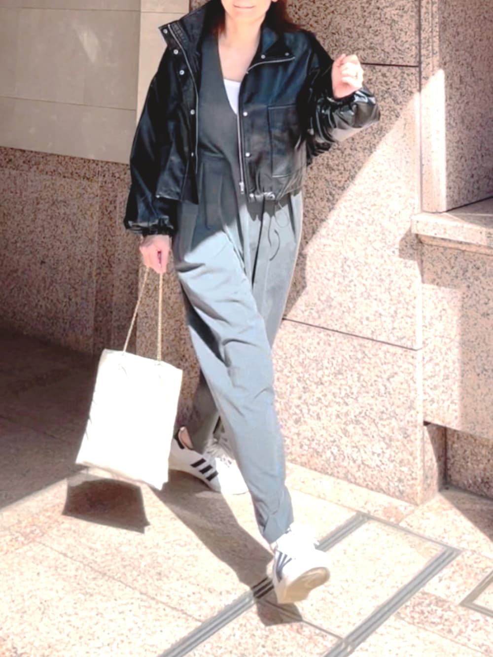 ブラック系のブルゾン、グレー系のつなぎ/オールインワン、ホワイト系のスニーカーを着用したレディースの秋コーディネートの3枚目の写真