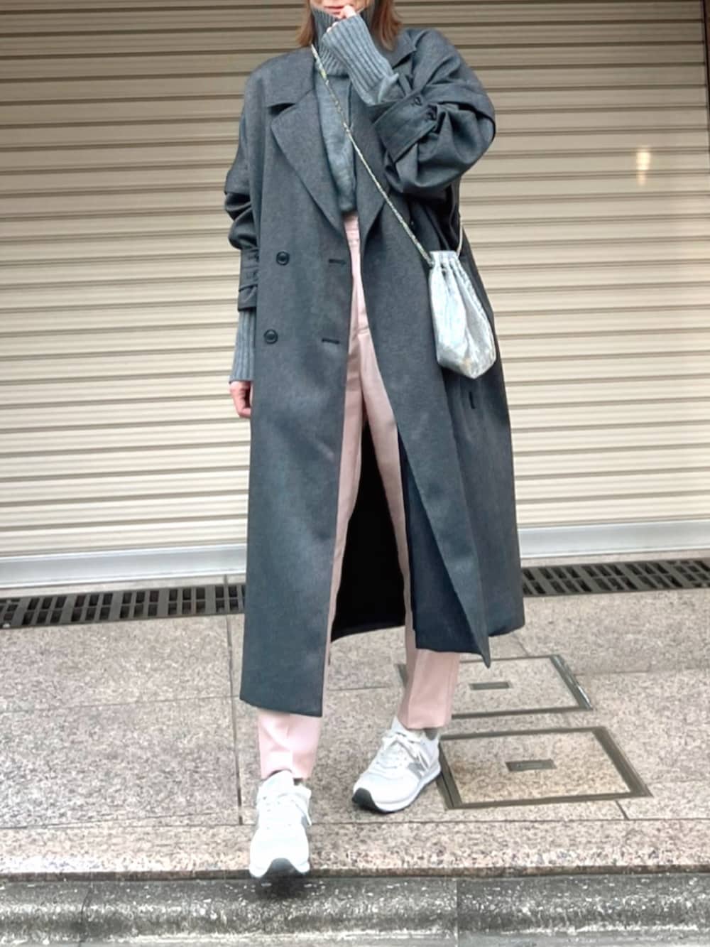 グレー系のチェスターコート、グレー系のニット/セーター、ピンク系のその他パンツを着用したレディースの冬コーディネートの2枚目の写真