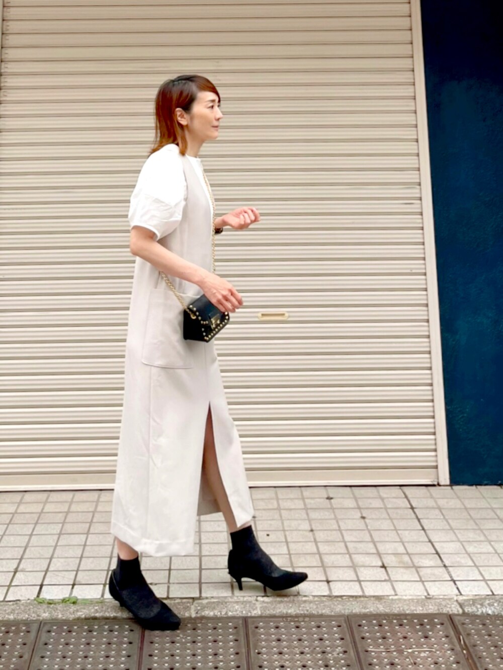 ベージュ系のワンピース、ブラック系のパンプス、ブラック系のバッグを着用したレディースの夏コーディネートの3枚目の写真