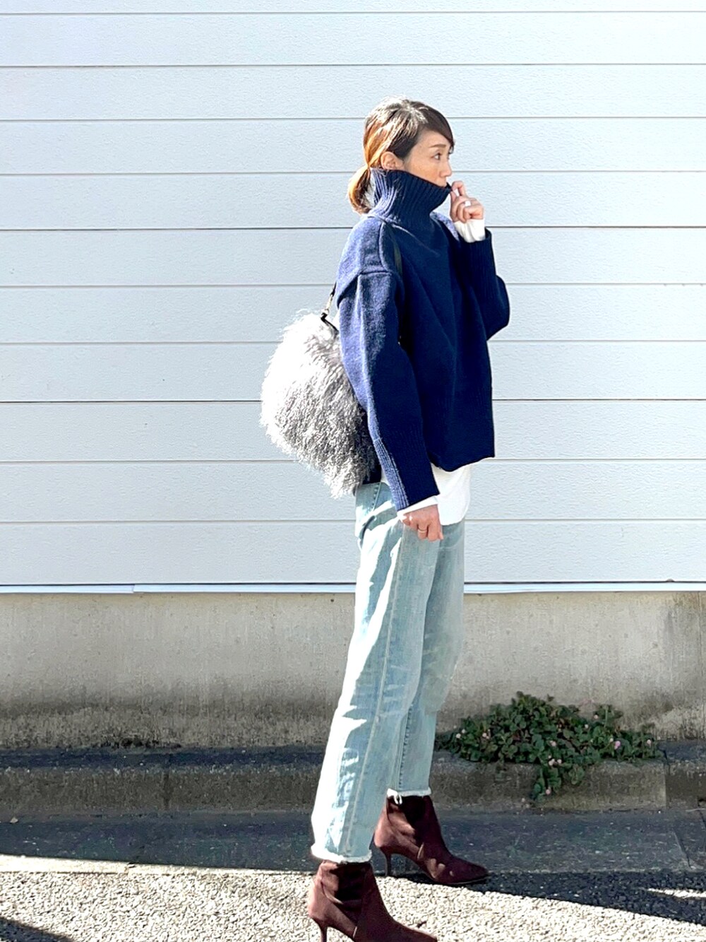 ブルー系のニット/セーター、ブルー系のデニムパンツを着用したレディースの秋コーディネートの3枚目の写真