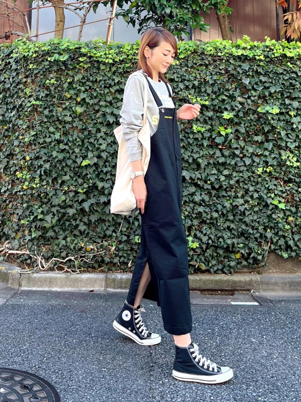 ブラック系のスカート、グレー系のTシャツ/カットソー、ホワイト系のトートバッグを着用したレディースの秋コーディネートの2枚目の写真