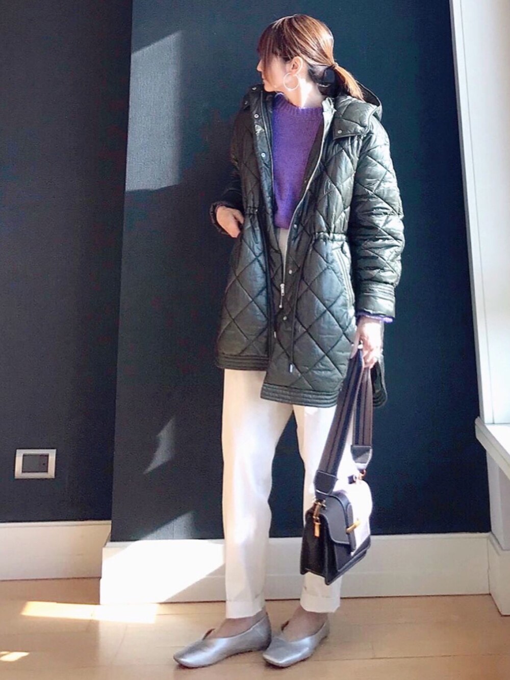 グリーン系のブルゾン、パープル系のニット/セーター、ホワイト系のその他パンツを着用したレディースの冬コーディネートの2枚目の写真