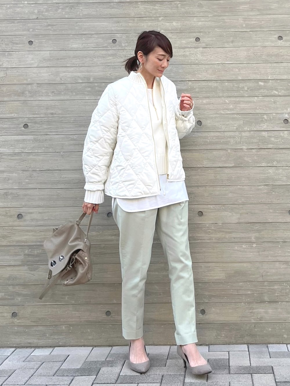 ホワイト系のその他アウター、グレー系のハンドバッグ、ホワイト系のニット/セーターを着用したレディースの冬コーディネートの2枚目の写真