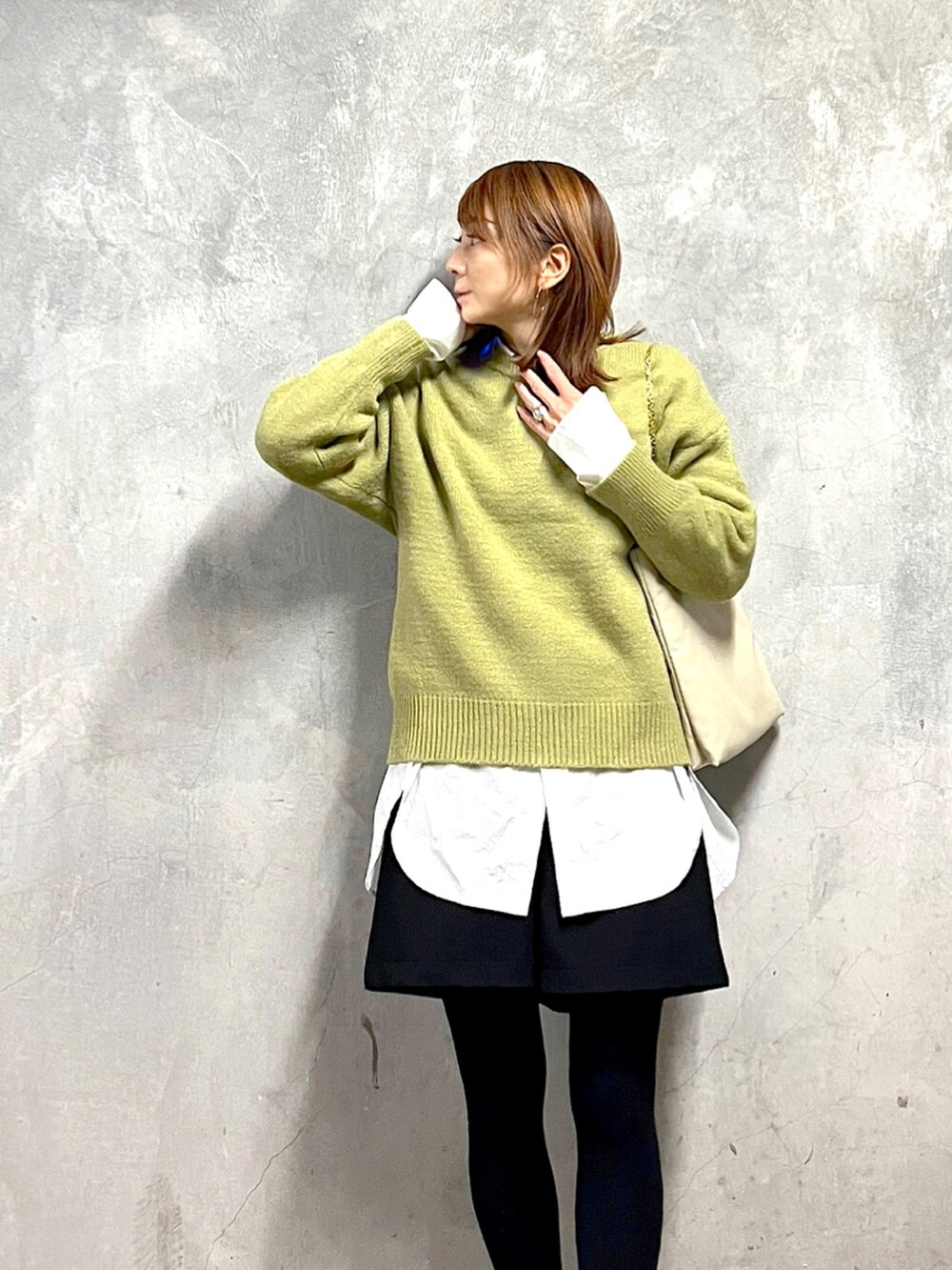 ブラック系のドレスシューズ、グリーン系のニット/セーター、ホワイト系のシャツ/ブラウスを着用したレディースの冬コーディネートの2枚目の写真