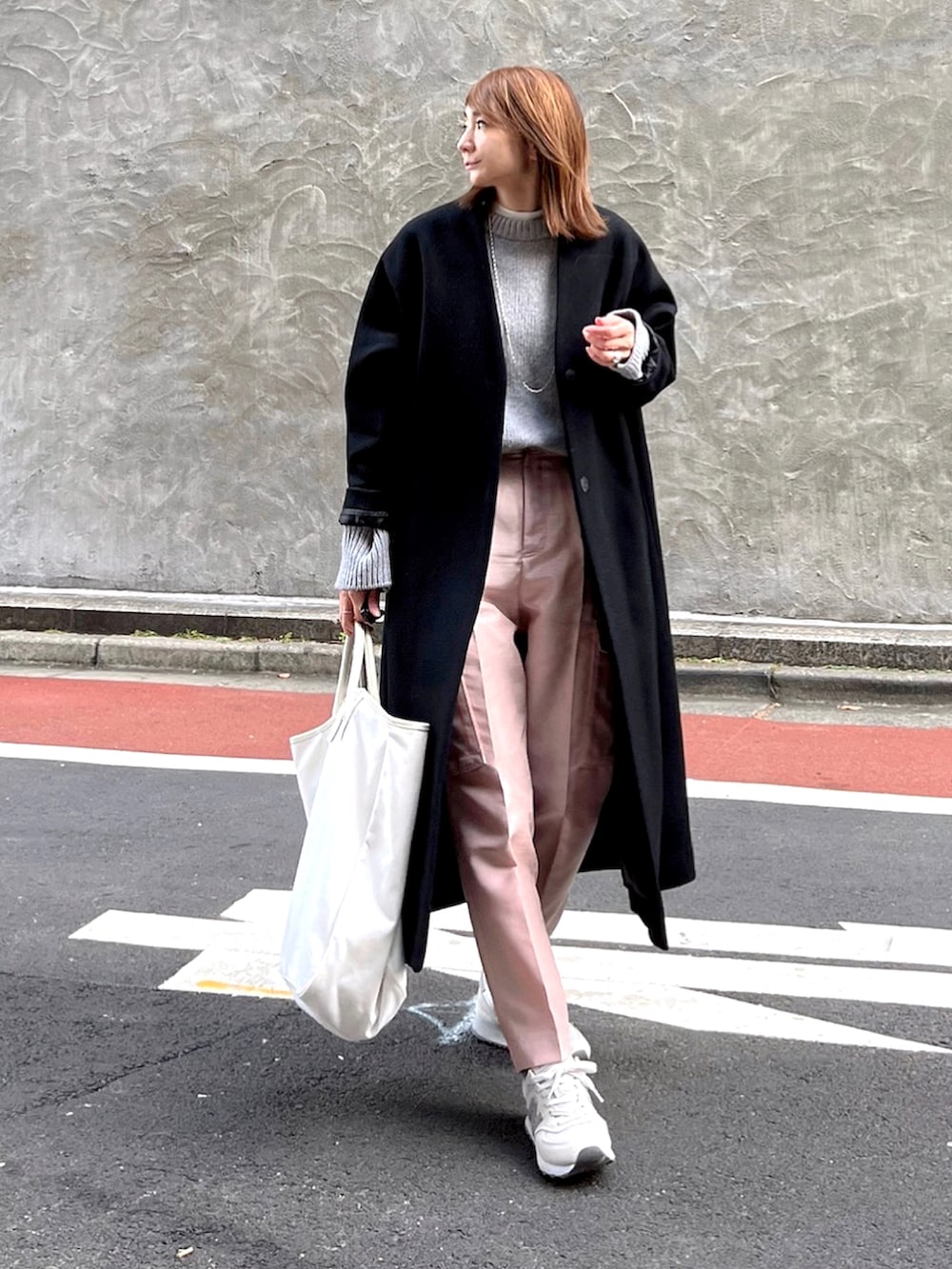 ピンク系のその他パンツ、ブラック系のノーカラーコート、ホワイト系のトートバッグを着用したレディースの冬コーディネートの2枚目の写真