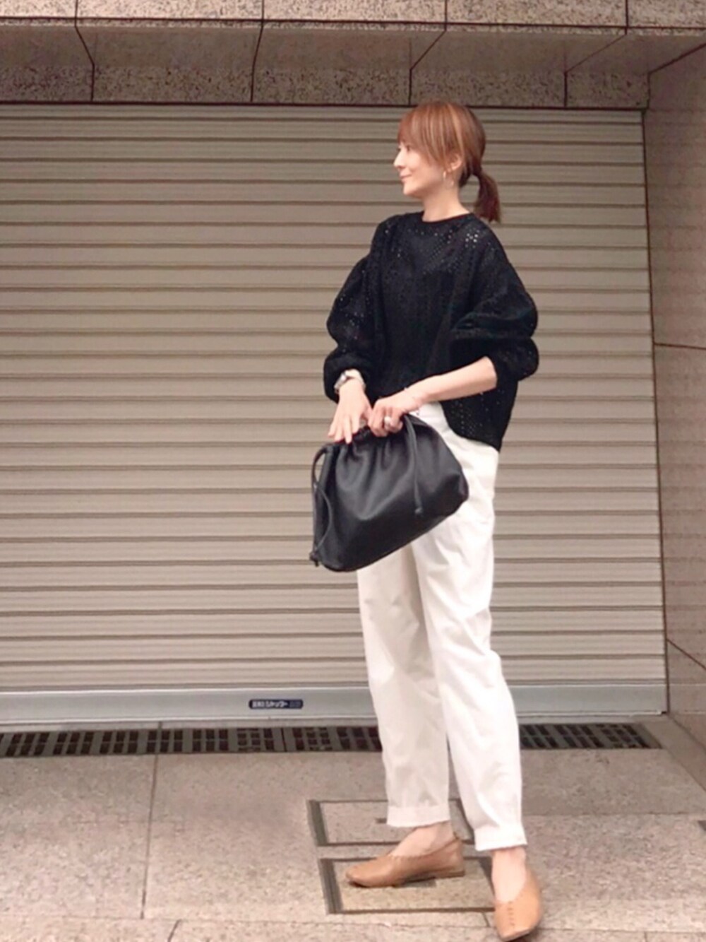 ブラック系のシャツ/ブラウス、ブラウン系のハンドバッグ、ベージュ系のパンプスを着用したレディースの春コーディネートの2枚目の写真