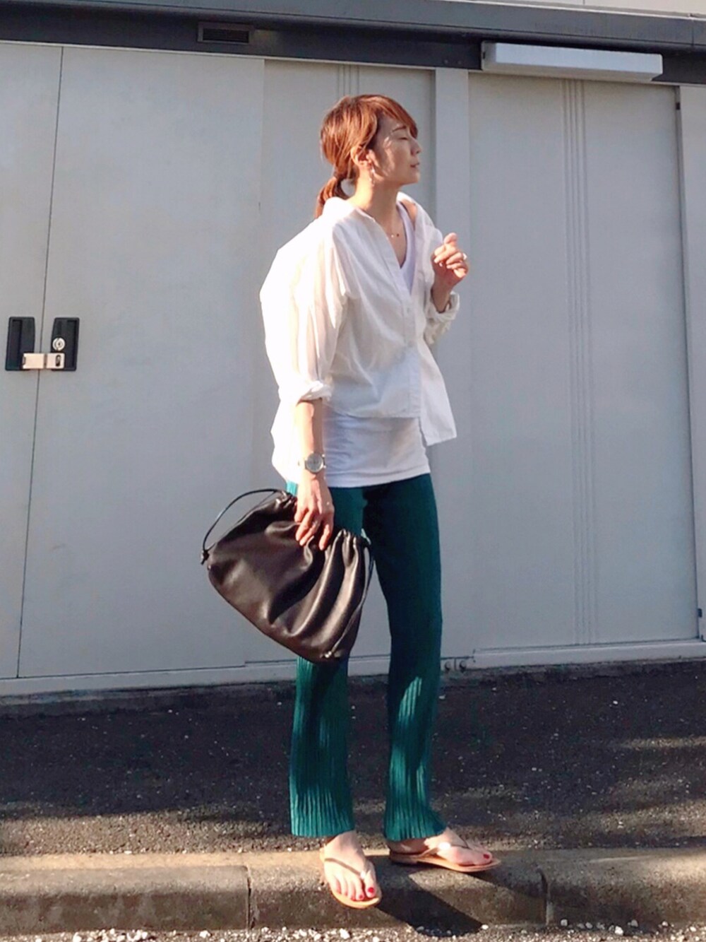 ブラウン系のハンドバッグ、ブルー系のその他パンツ、ゴールド系のサンダルを着用したレディースの夏コーディネートの2枚目の写真