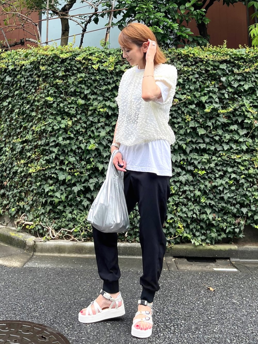 シルバー系のエコバッグ/サブバッグ、ホワイト系のシャツ/ブラウス、ブラック系のその他パンツを着用したレディースの秋コーディネートの3枚目の写真