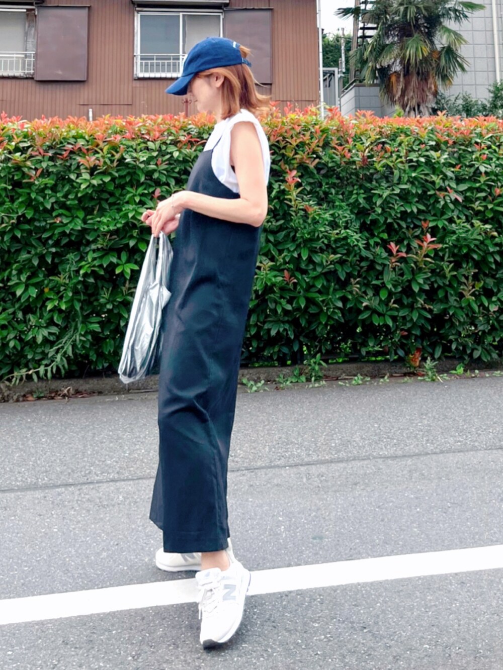 ブラック系のワンピース、ホワイト系のスニーカー、ホワイト系のTシャツ/カットソーを着用したレディースの夏コーディネートの4枚目の写真