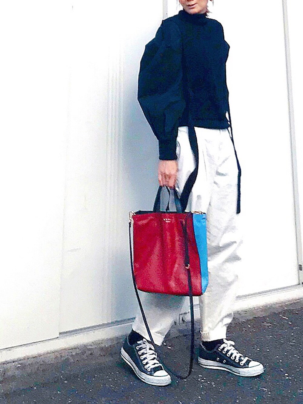 ブラック系のニット/セーター、ブラック系のニット/セーター、レッド系のトートバッグを着用したレディースの春コーディネートの2枚目の写真