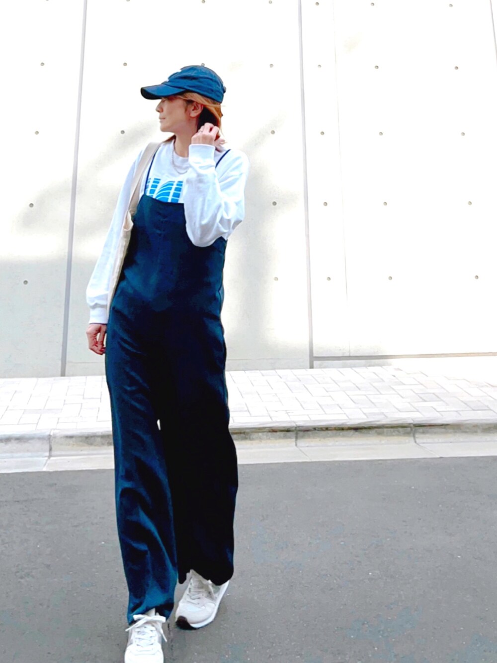 ブルー系のつなぎ/オールインワン、ホワイト系のスウェット、ホワイト系のスニーカーを着用したレディースの春コーディネートの2枚目の写真