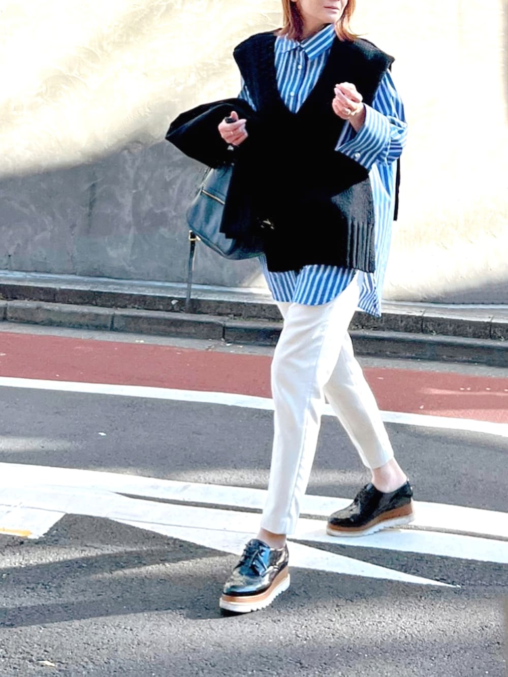 ブルー系のシャツ/ブラウス、ブラック系のドレスシューズ、ブラック系のニット/セーターを着用したレディースの秋コーディネートの2枚目の写真