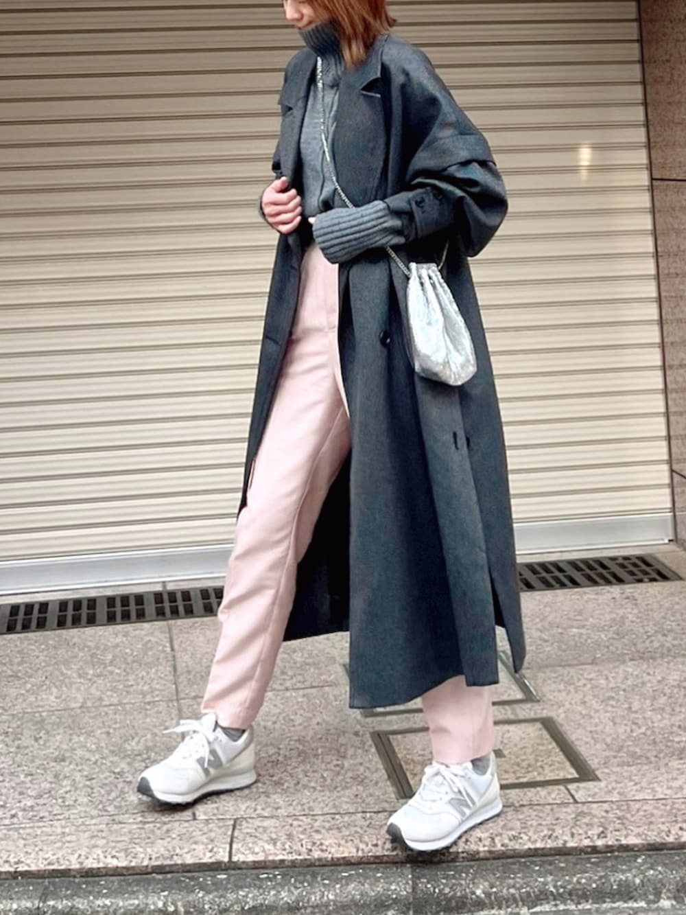 グレー系のチェスターコート、グレー系のニット/セーター、ピンク系のその他パンツを着用したレディースの冬コーディネートの3枚目の写真