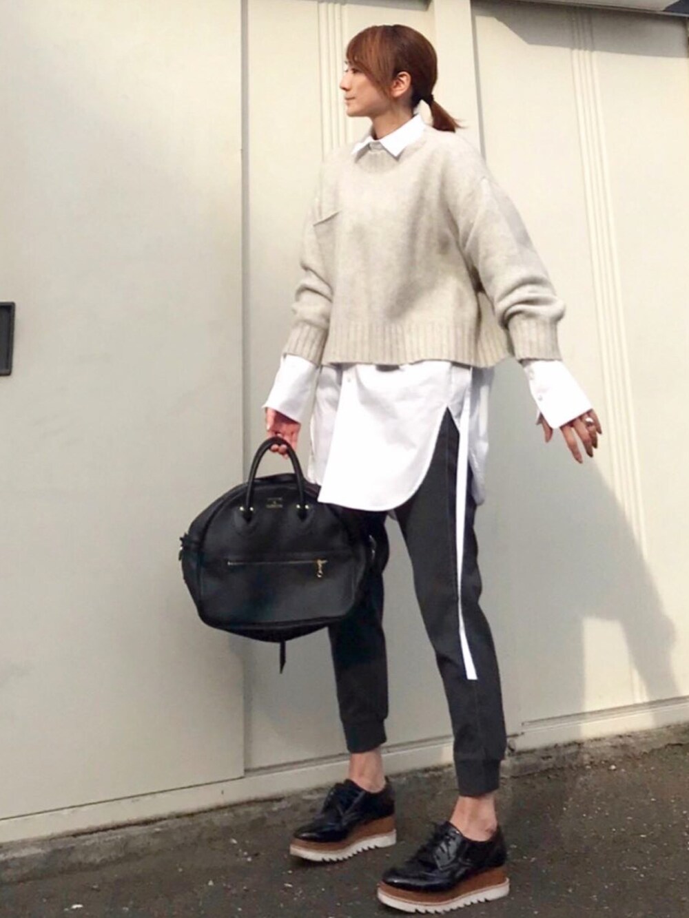 ホワイト系のシャツ/ブラウス、グレー系のニット/セーター、ブラック系のドレスシューズを着用したレディースの春コーディネートの2枚目の写真