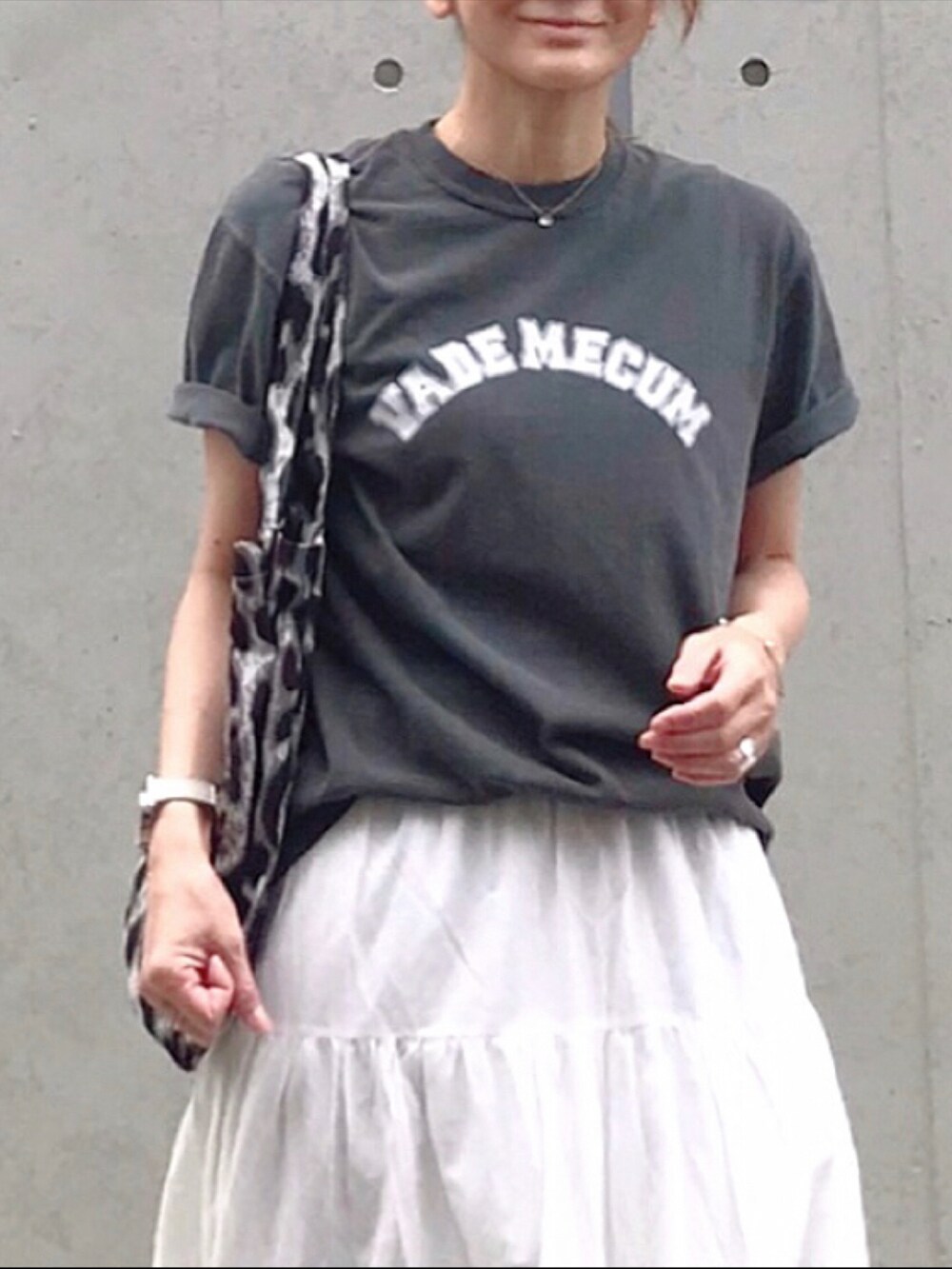 ホワイト系のスカート、グレー系のトートバッグ、ゴールド系のサンダルを着用したレディースの春コーディネートの2枚目の写真