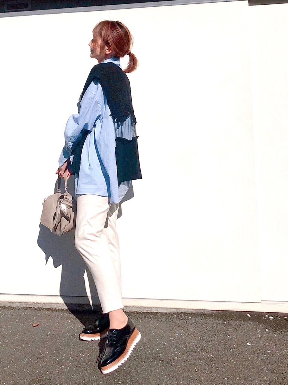 グレー系のハンドバッグ、ホワイト系のその他パンツ、ブラック系のドレスシューズを着用したレディースの冬コーディネートの2枚目の写真