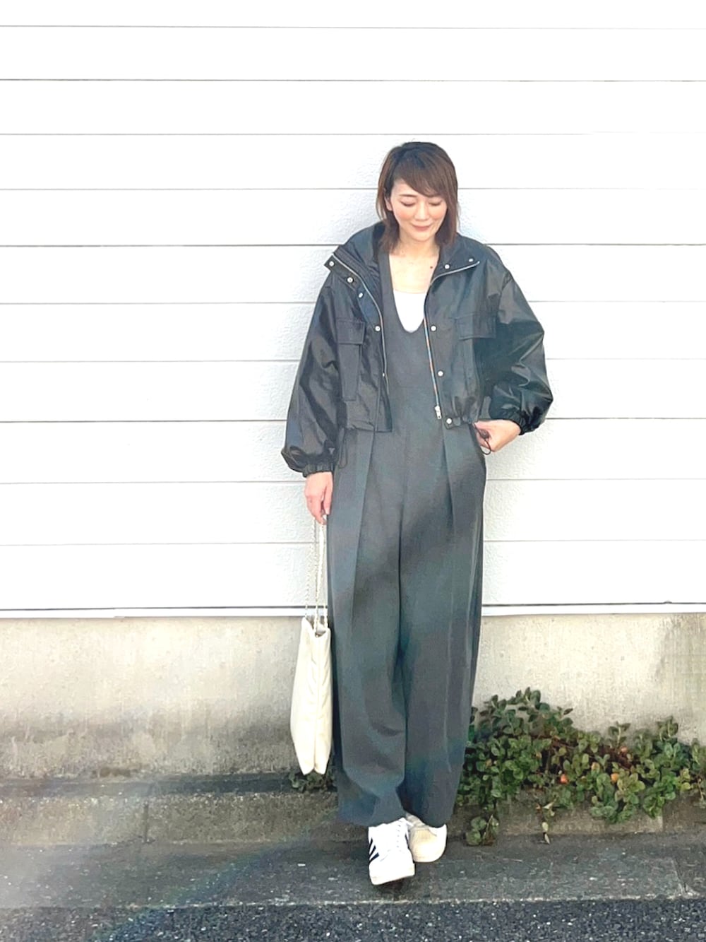 ブラック系のブルゾン、グレー系のつなぎ/オールインワン、ホワイト系のスニーカーを着用したレディースの秋コーディネートの2枚目の写真