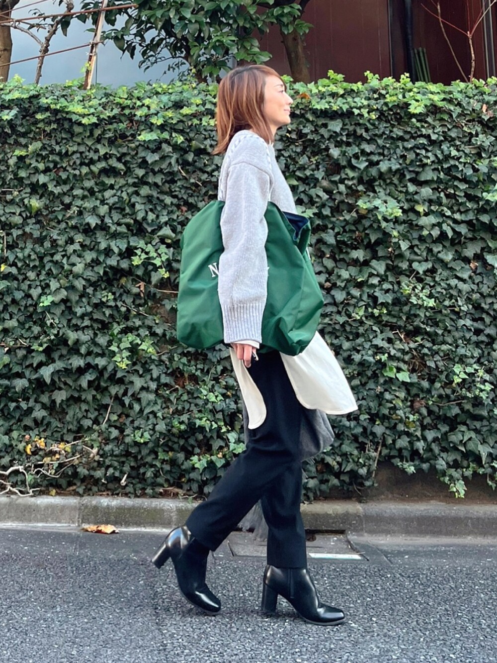 グリーン系のトートバッグ、ブラック系のその他パンツ、ブラック系のブーツを着用したレディースの秋コーディネートの2枚目の写真