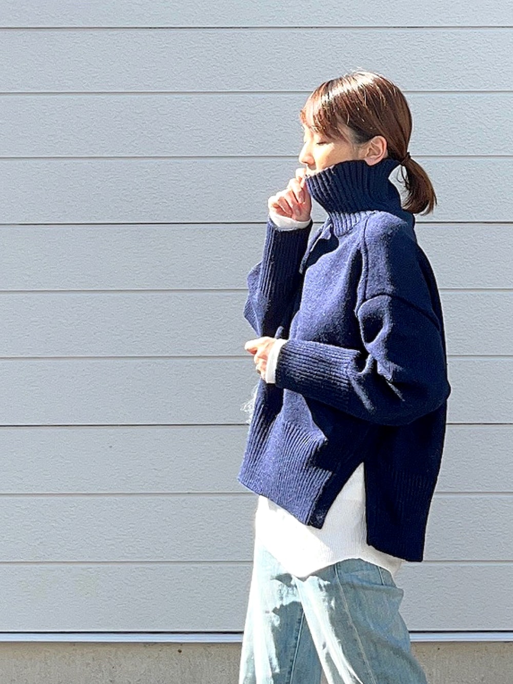 ブルー系のニット/セーター、ブルー系のデニムパンツを着用したレディースの秋コーディネートの2枚目の写真