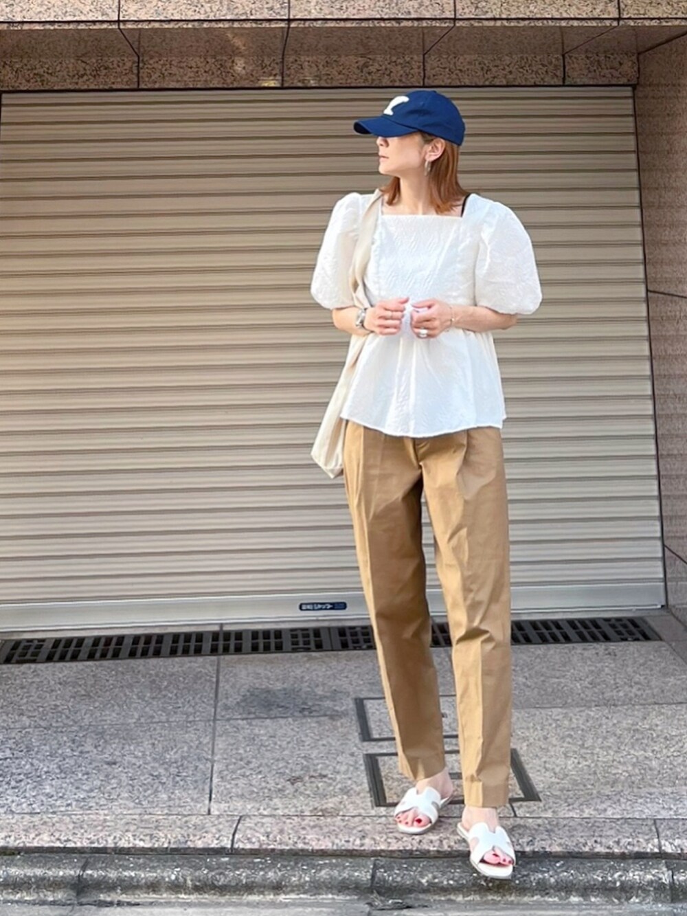 ホワイト系のシャツ/ブラウス、イエロー系のチノパンツ、ホワイト系のサンダルを着用したレディースの夏コーディネートの3枚目の写真