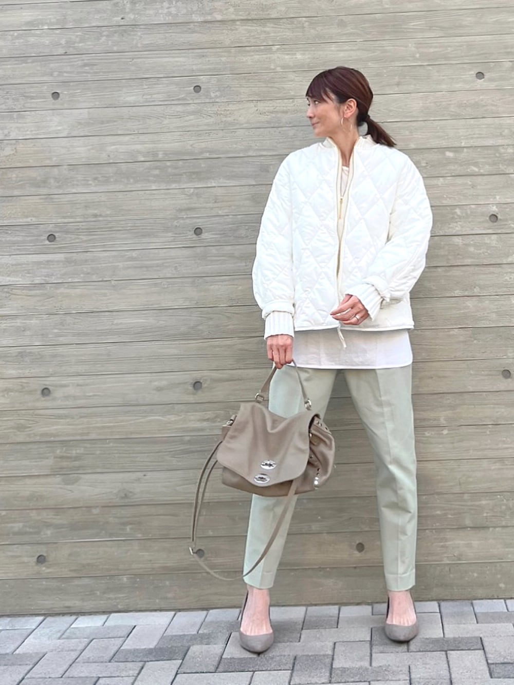 ホワイト系のその他アウター、グレー系のハンドバッグ、ホワイト系のニット/セーターを着用したレディースの冬コーディネートの4枚目の写真