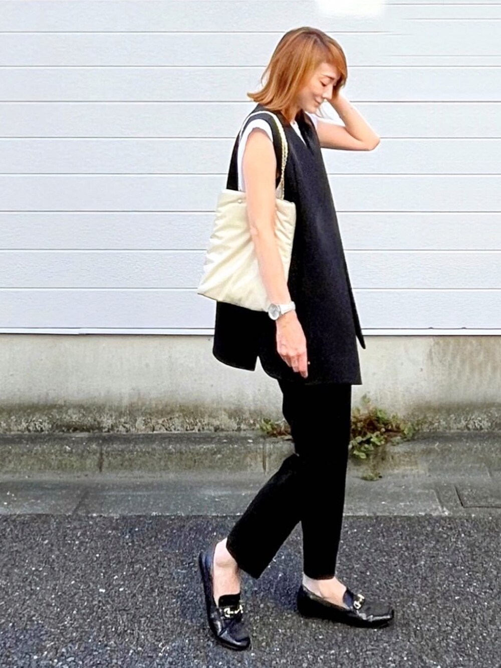 ホワイト系のトートバッグ、ブラック系のその他アウター、ブラック系のその他パンツを着用したレディースの秋コーディネートの3枚目の写真