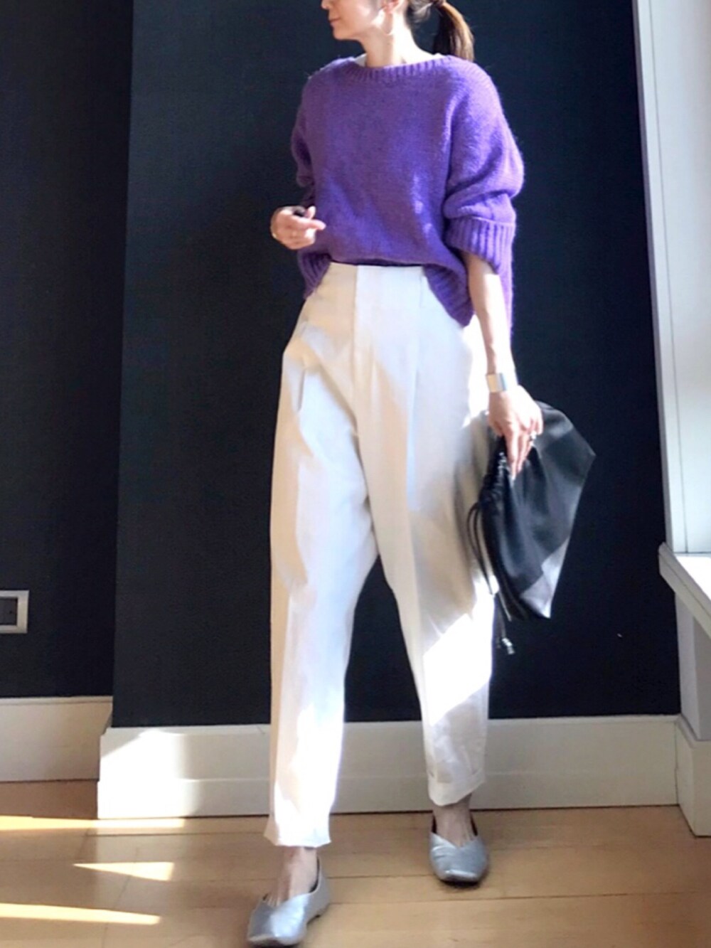 パープル系のニット/セーター、ブラウン系のハンドバッグ、ホワイト系のその他パンツを着用したレディースの冬コーディネートの2枚目の写真