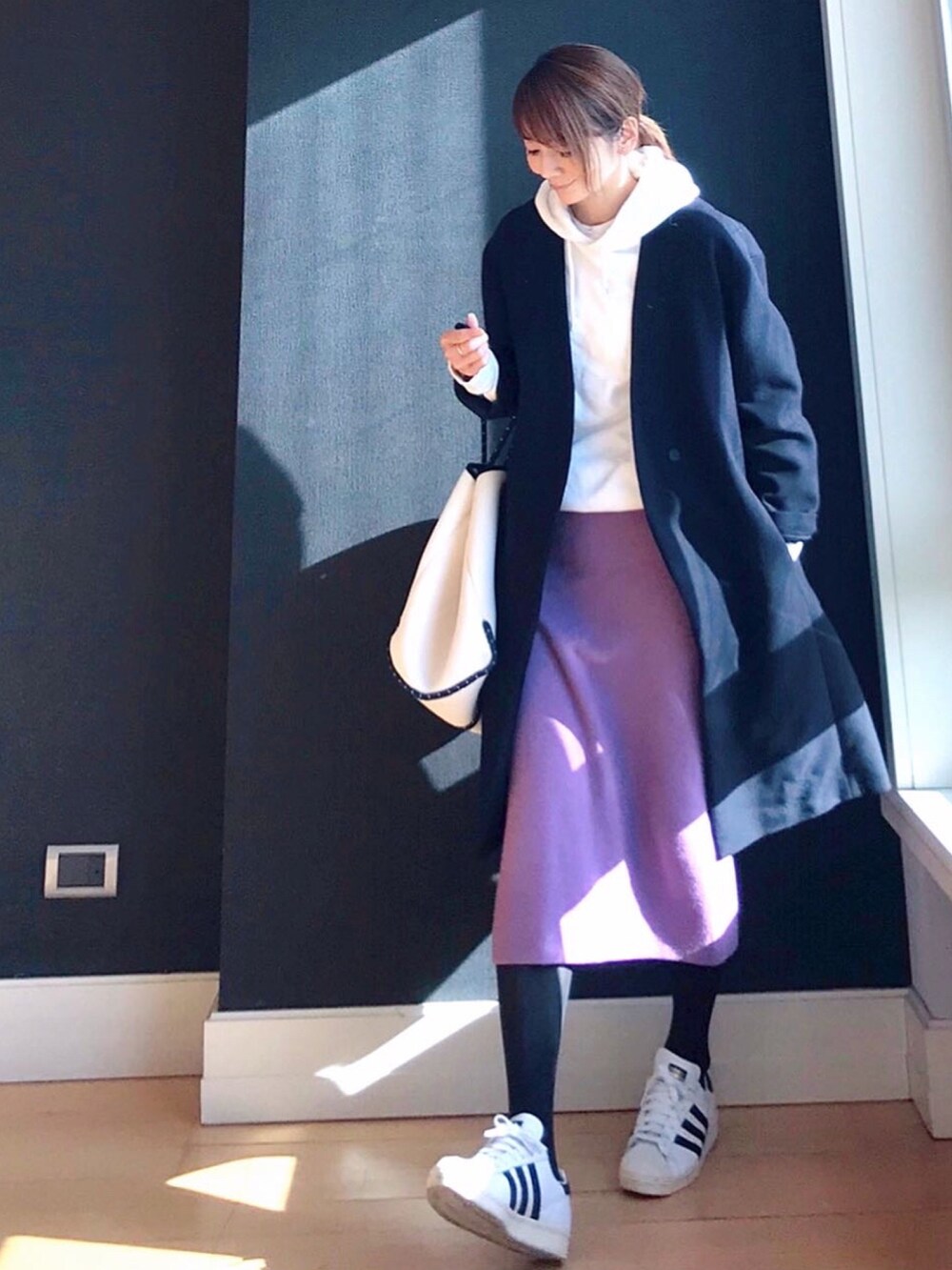 ブルー系のその他アウター、ホワイト系のトートバッグ、ホワイト系のスニーカーを着用したレディースの冬コーディネートの2枚目の写真