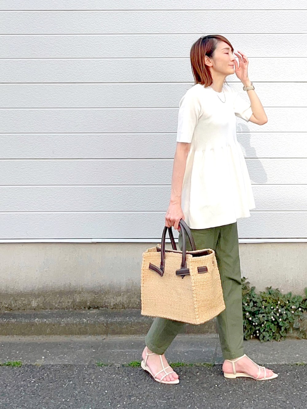 ホワイト系のニット/セーター、ホワイト系のサンダルを着用したレディースの春コーディネートの2枚目の写真