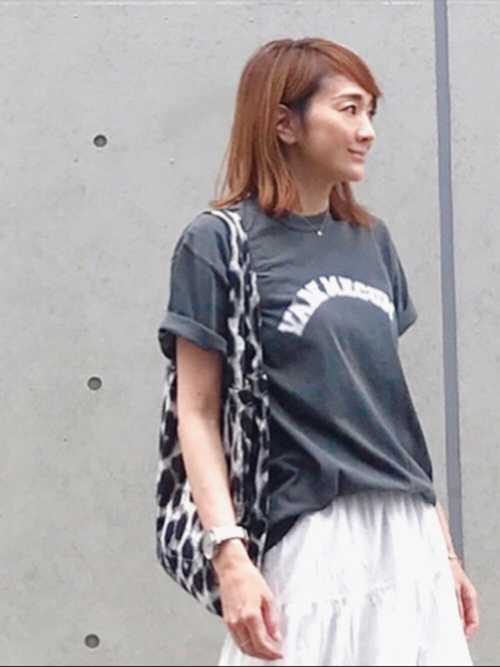 ホワイト系のスカート、グレー系のトートバッグ、ゴールド系のサンダルを着用したレディースの春コーディネートの4枚目の写真