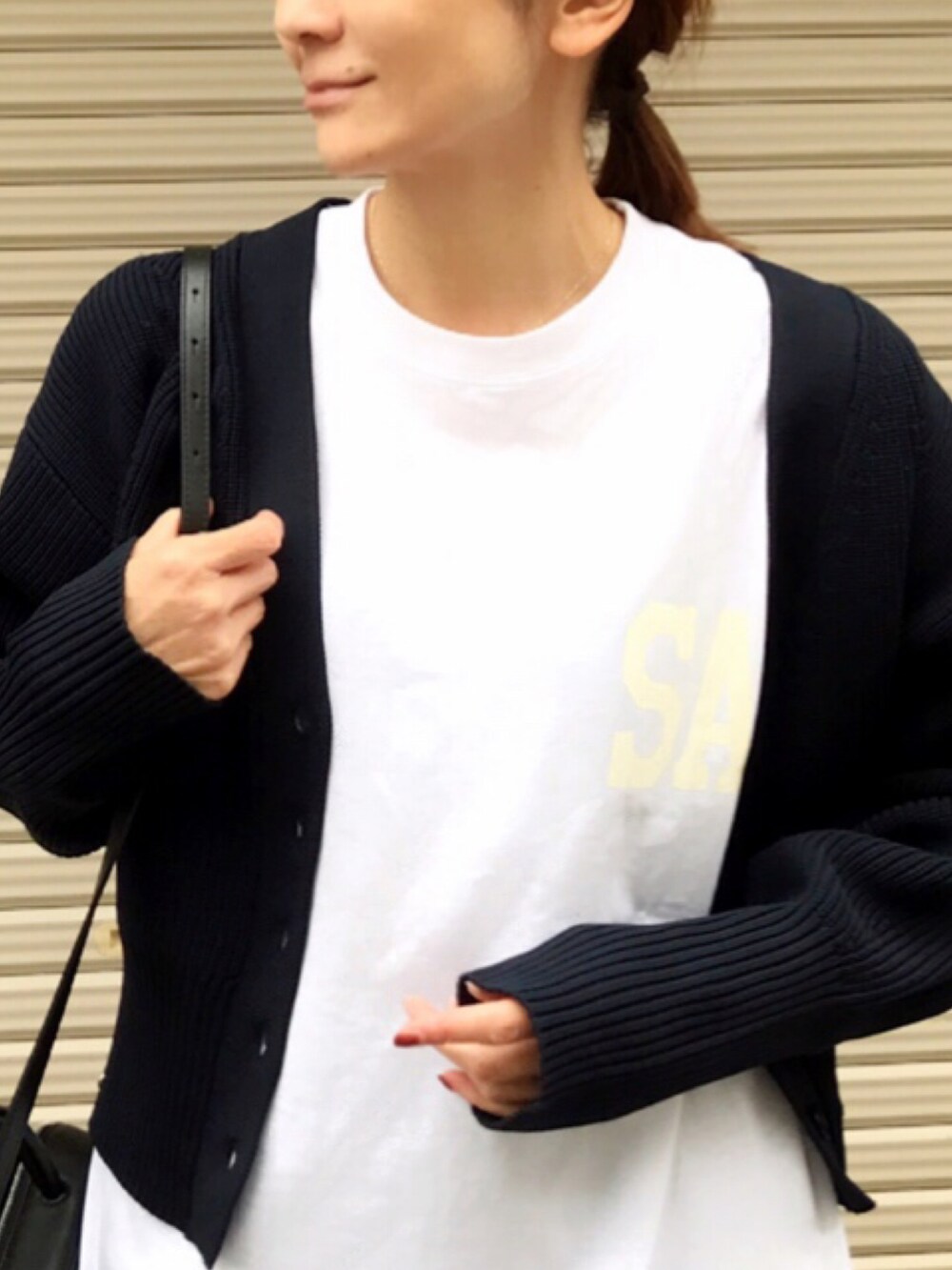 ホワイト系のTシャツ/カットソー、ブルー系のその他パンツ、ブラック系のハンドバッグを着用したレディースの春コーディネートの3枚目の写真