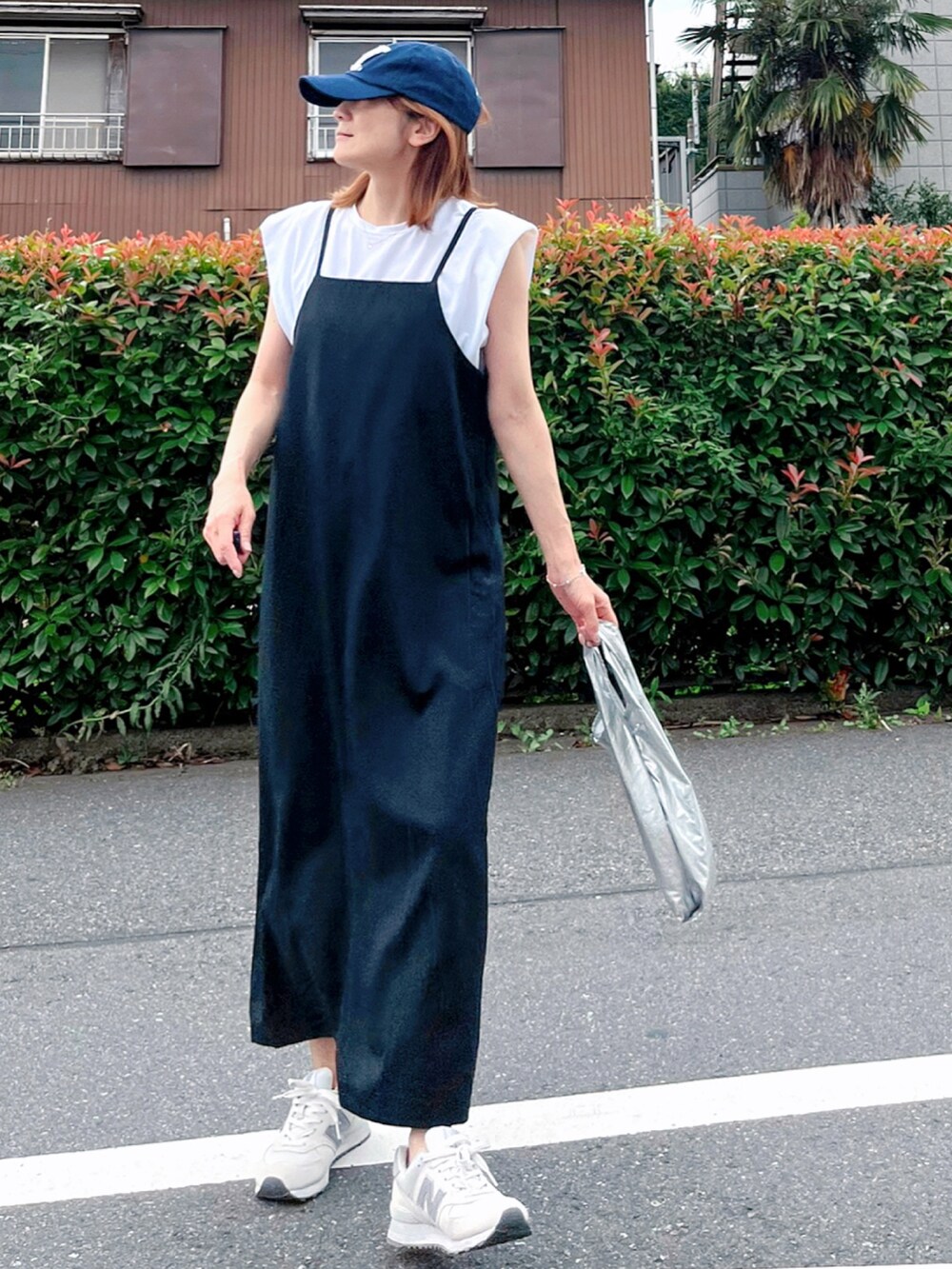 ブラック系のワンピース、ホワイト系のスニーカー、ホワイト系のTシャツ/カットソーを着用したレディースの夏コーディネートの3枚目の写真