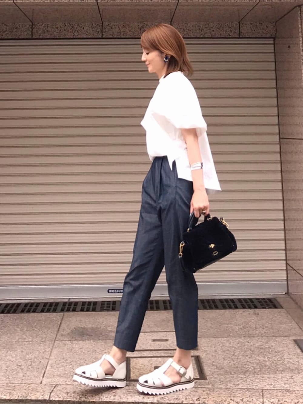 ブルー系のその他パンツ、ホワイト系のシャツ/ブラウス、ブルー系のショルダーバッグを着用したレディースの夏コーディネートの2枚目の写真