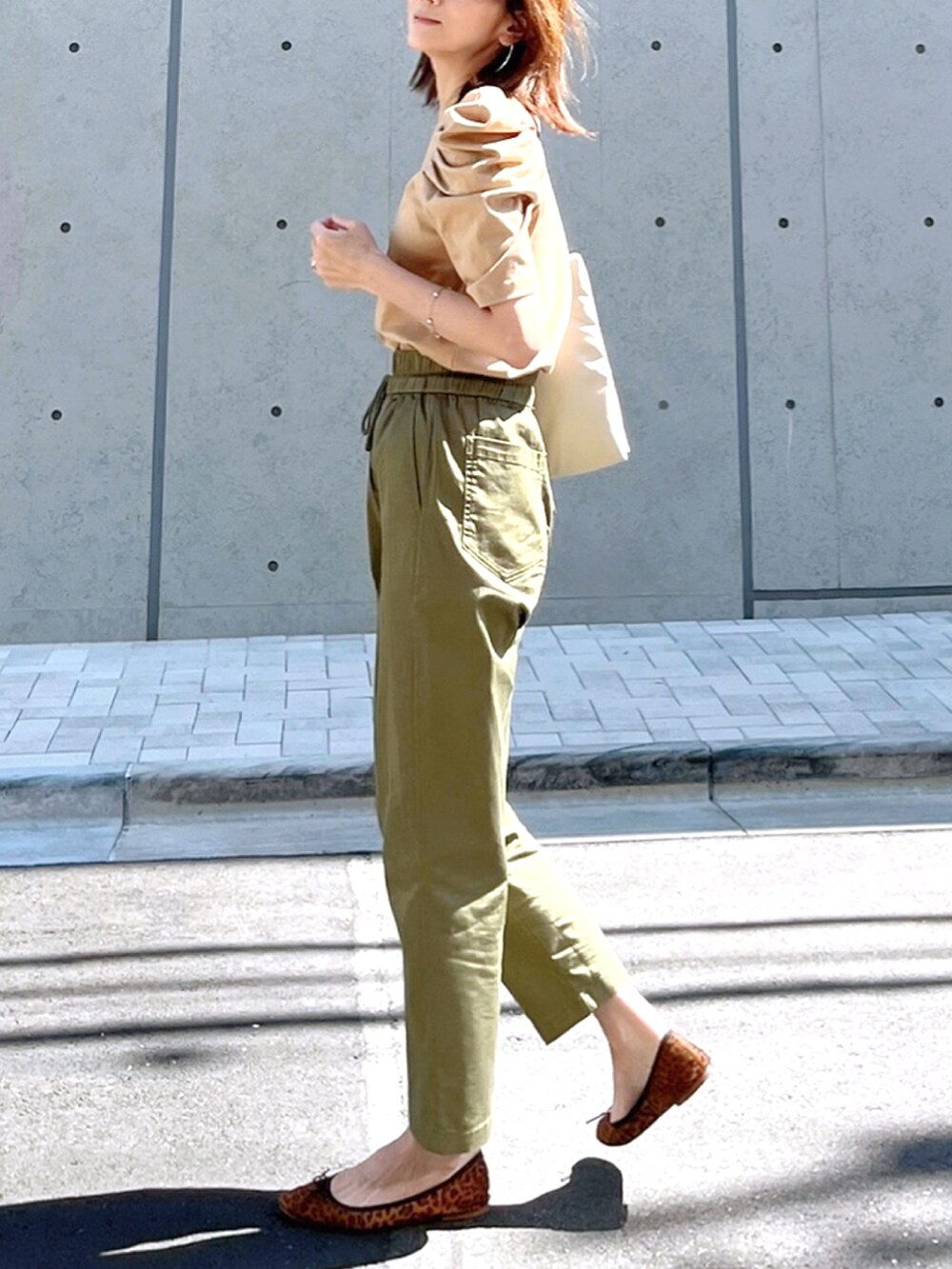 ホワイト系のトートバッグ、ベージュ系のTシャツ/カットソー、グリーン系のその他パンツを着用したレディースの秋コーディネートの2枚目の写真