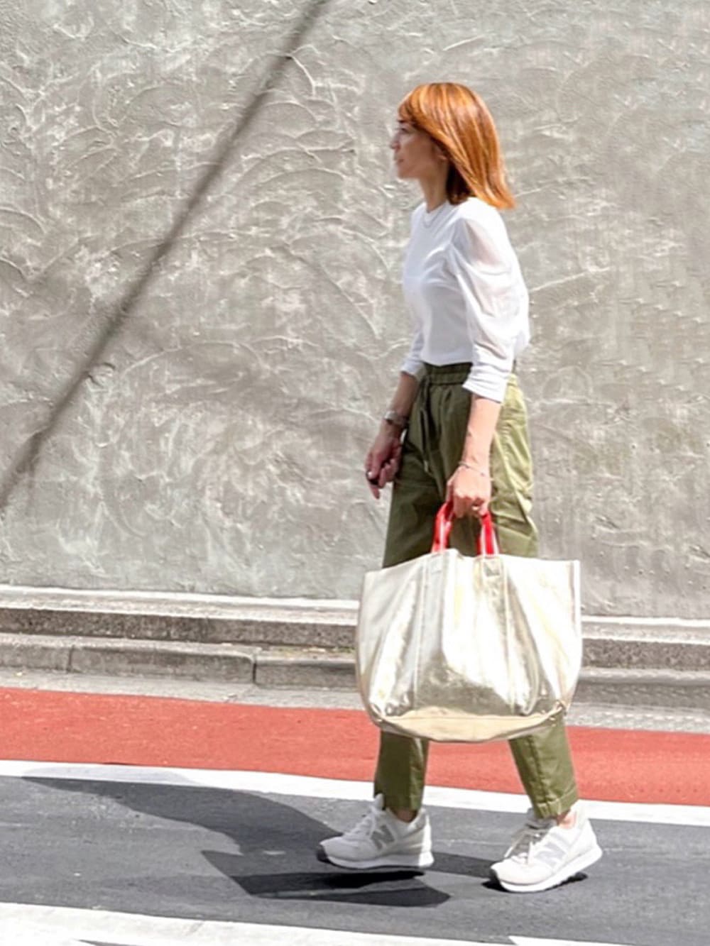 ホワイト系のTシャツ/カットソー、グリーン系のその他パンツ、ホワイト系のスニーカーを着用したレディースの秋コーディネートの2枚目の写真