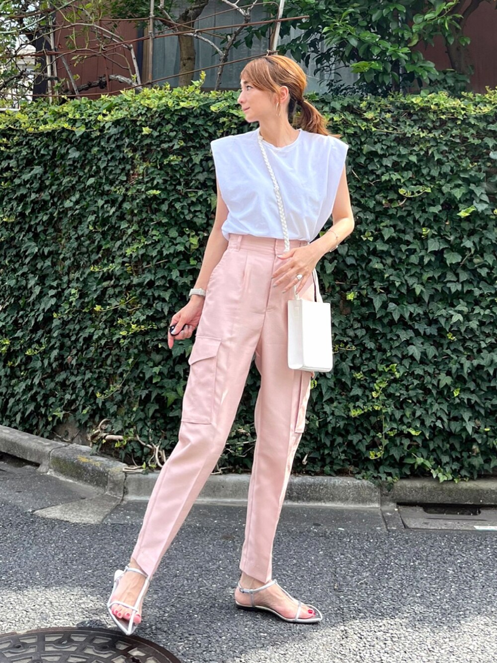 ピンク系のその他パンツ、ホワイト系のTシャツ/カットソー、ホワイト系のショルダーバッグを着用したレディースの夏コーディネートの2枚目の写真