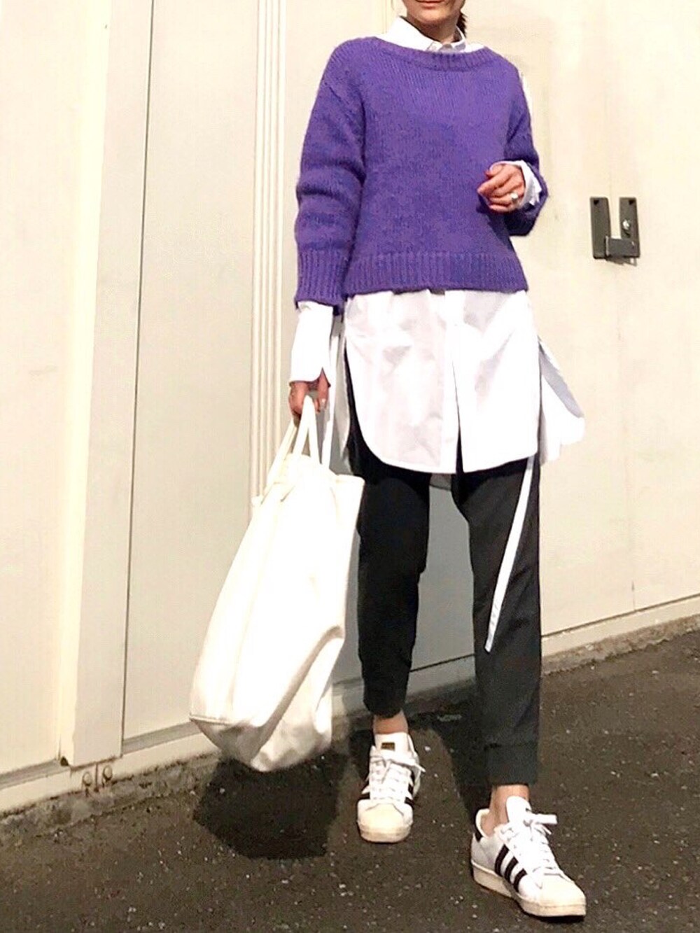 ホワイト系のシャツ/ブラウス、パープル系のニット/セーター、ホワイト系のスニーカーを着用したレディースの春コーディネートの2枚目の写真