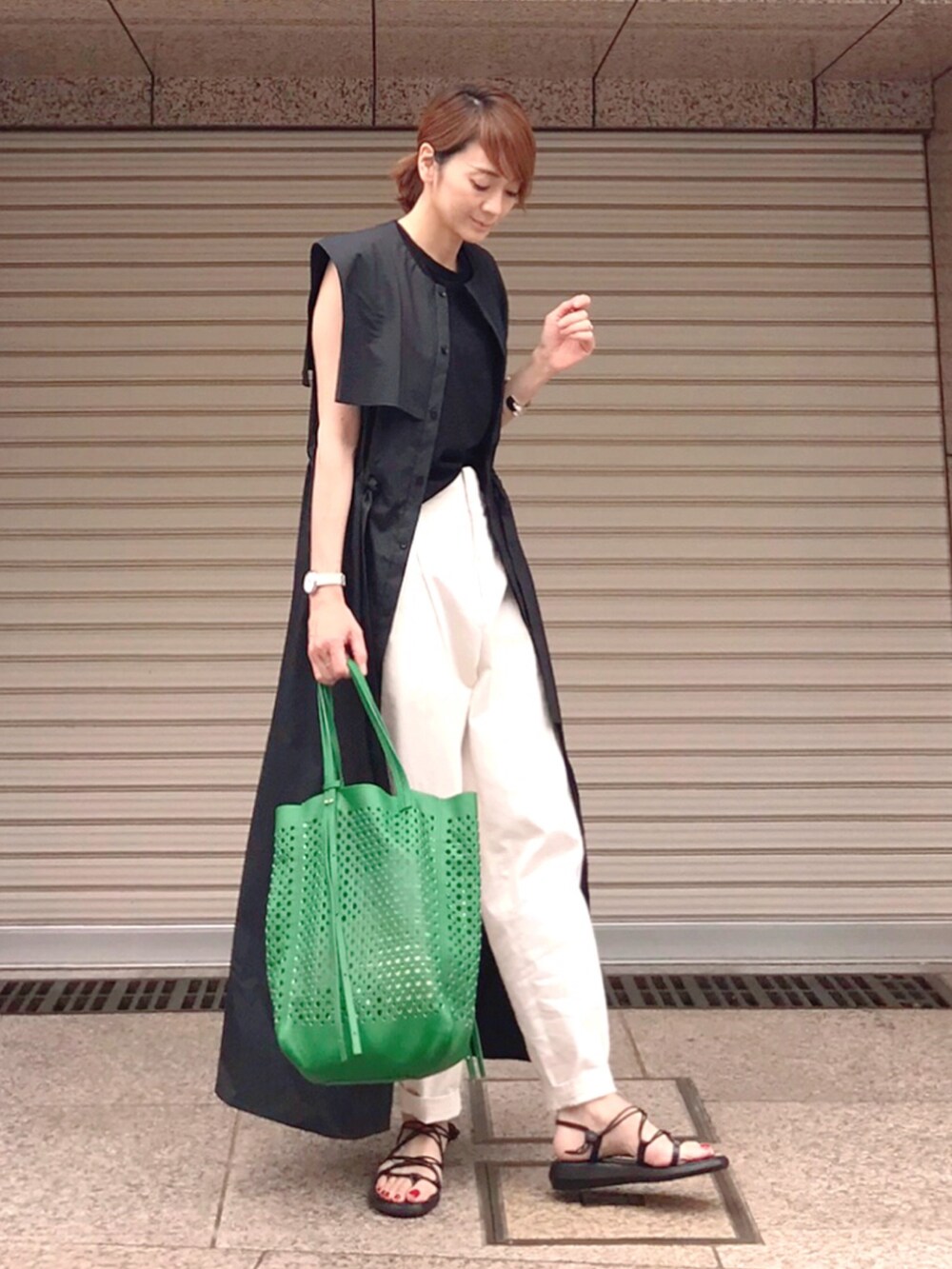 グリーン系のトートバッグ、ブラック系のワンピース、ホワイト系のその他パンツを着用したレディースの夏コーディネートの3枚目の写真