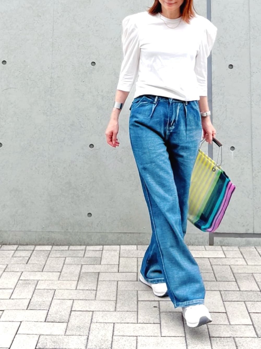 ブルー系のデニムパンツ、ホワイト系のTシャツ/カットソー、その他のバッグを着用したレディースの春コーディネートの2枚目の写真