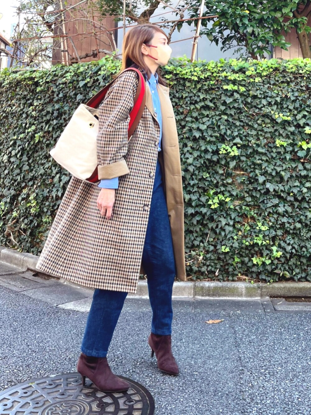 ブルー系のデニムパンツ、ベージュ系のステンカラーコート、ブルー系のシャツ/ブラウスを着用したレディースの秋コーディネートの2枚目の写真