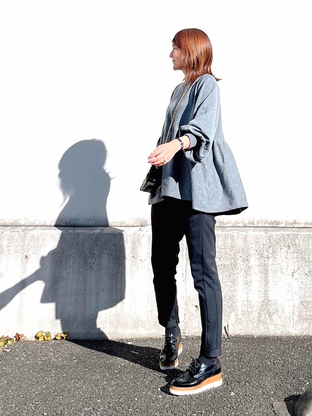 グレー系のニット/セーター、ブラック系のドレスシューズを着用したレディースの冬コーディネートの2枚目の写真