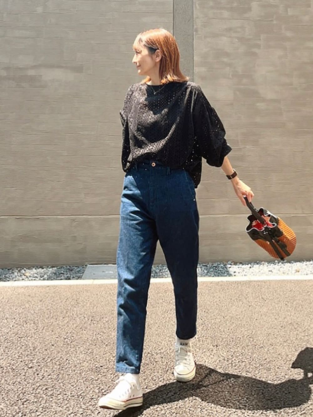 ブルー系のデニムパンツ、ブラック系のシャツ/ブラウス、ブラウン系のショルダーバッグを着用したレディースの夏コーディネートの2枚目の写真