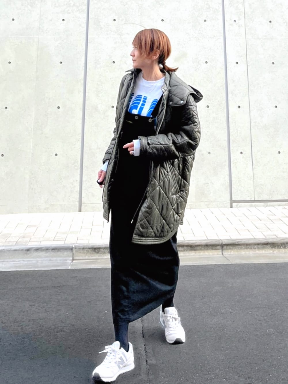 グリーン系のブルゾン、ブラック系のスカート、ホワイト系のスニーカーを着用したレディースの冬コーディネートの2枚目の写真