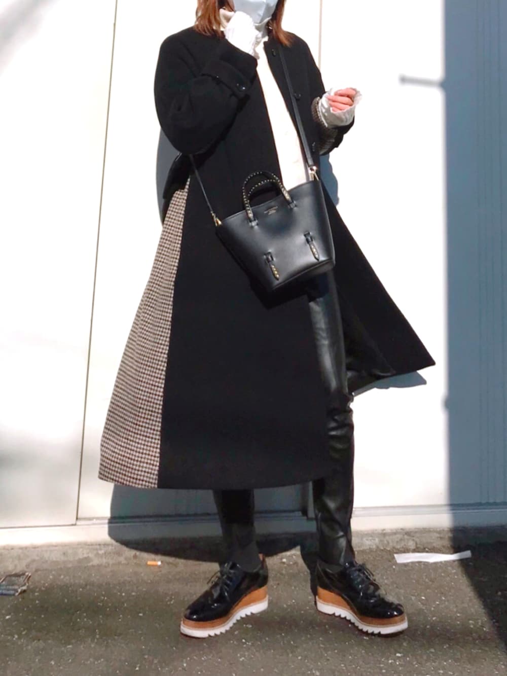 ホワイト系のニット/セーター、ブラック系のトートバッグ、ブラック系のドレスシューズを着用したレディースの冬コーディネートの2枚目の写真