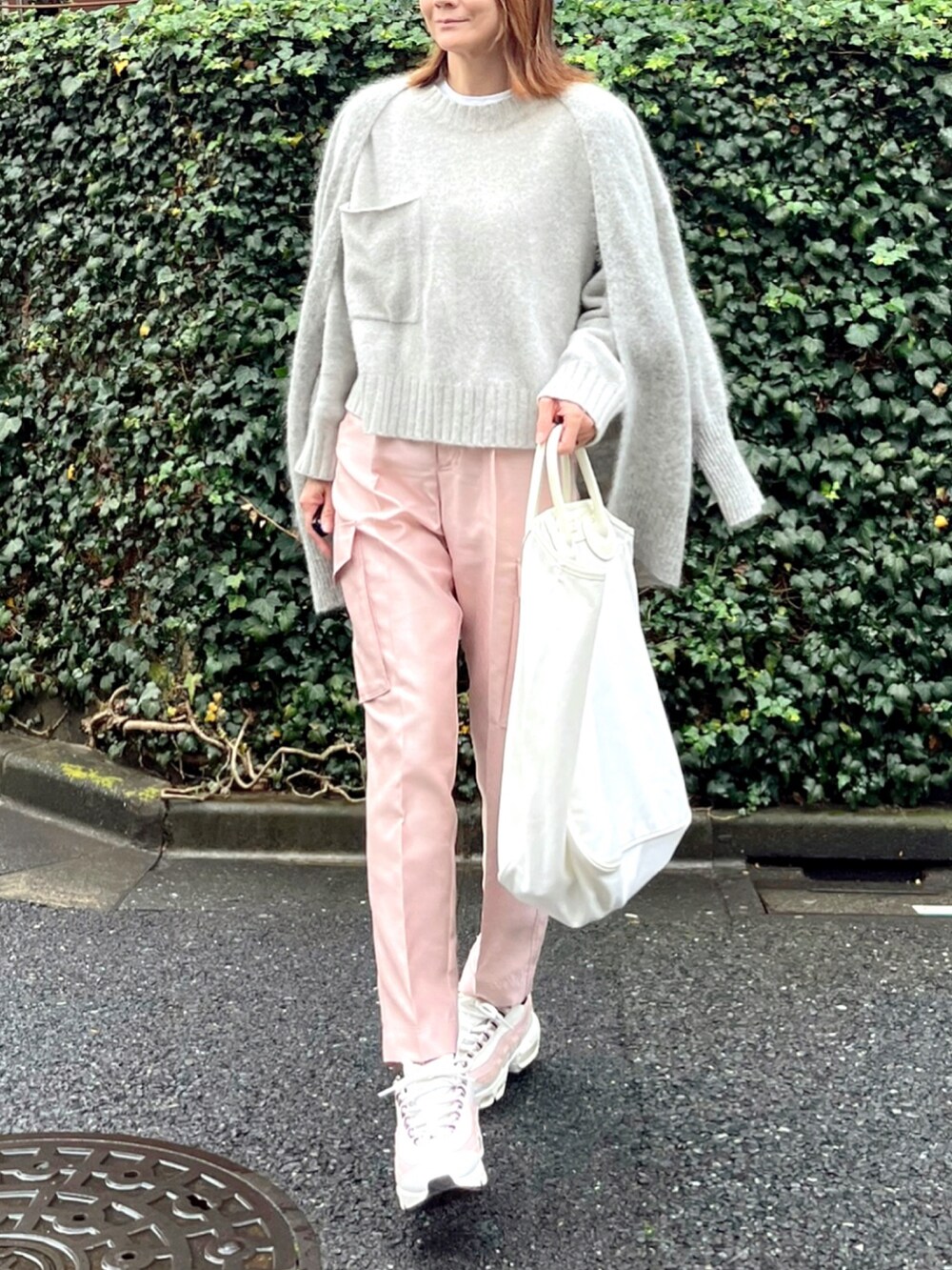 ホワイト系のトートバッグ、ホワイト系のスニーカー、グレー系のカーディガン/ボレロを着用したレディースの秋コーディネートの2枚目の写真